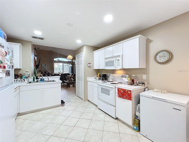 kitchen with sink, hanging light fixtures, kitchen peninsula, white appliances, and white cabinets