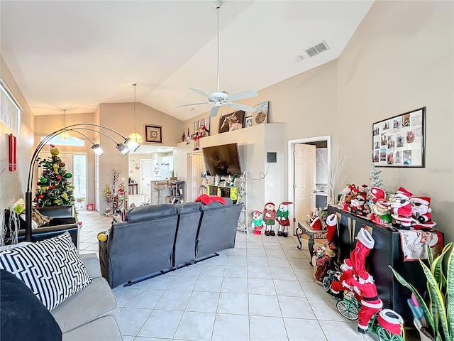 living room with ceiling fan, light tile patterned floors, and vaulted ceiling