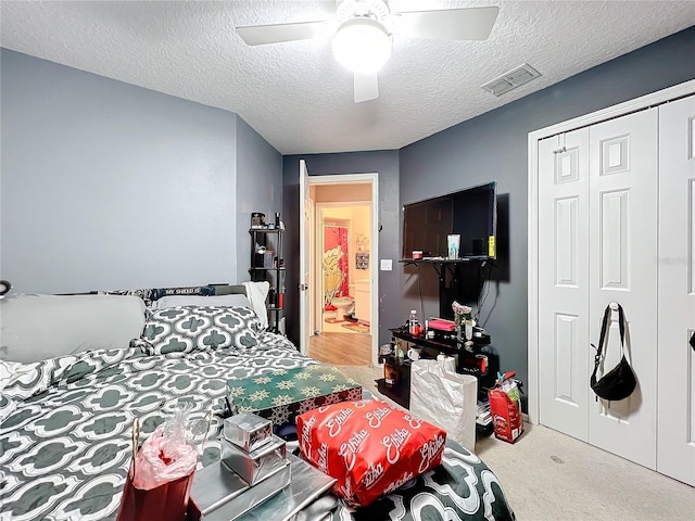 carpeted bedroom with ceiling fan and a textured ceiling