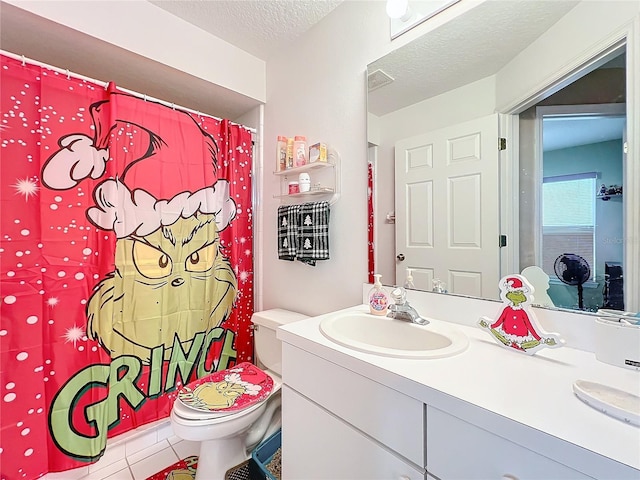 bathroom with tile patterned floors, vanity, toilet, and a textured ceiling