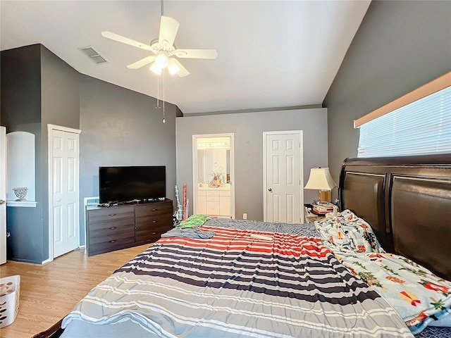 bedroom with ensuite bathroom, ceiling fan, light hardwood / wood-style floors, and vaulted ceiling