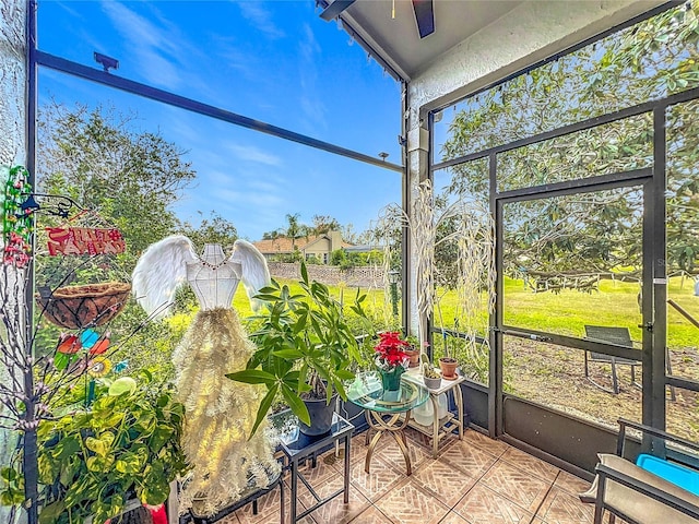 unfurnished sunroom featuring ceiling fan