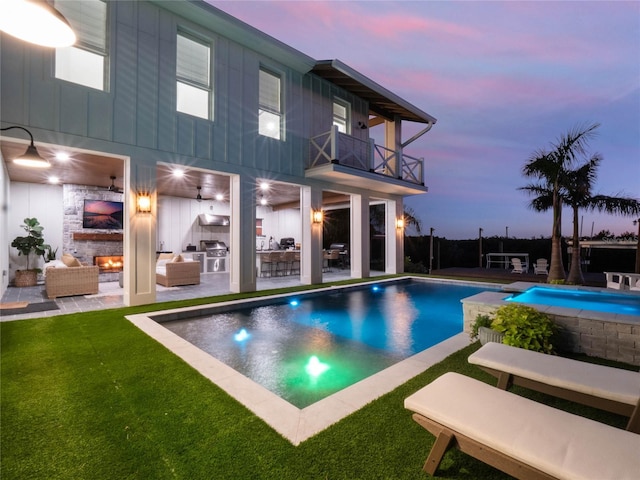 pool at dusk with area for grilling, an outdoor hangout area, a patio, and a yard