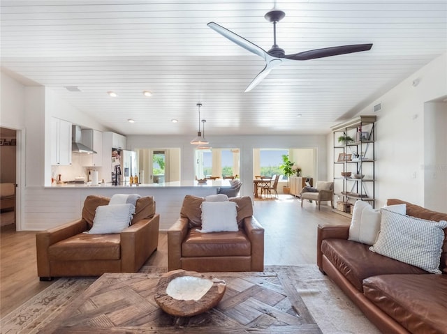 living room featuring ceiling fan and light hardwood / wood-style floors