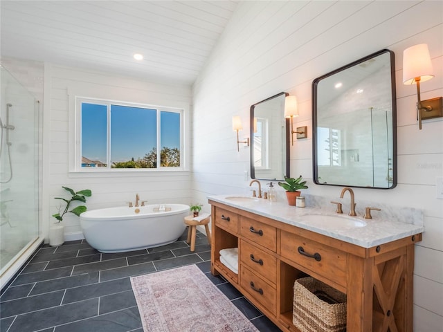 bathroom with tile patterned floors, vanity, separate shower and tub, and vaulted ceiling