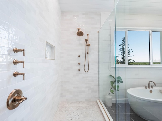 bathroom featuring tile patterned floors, independent shower and bath, and tile walls