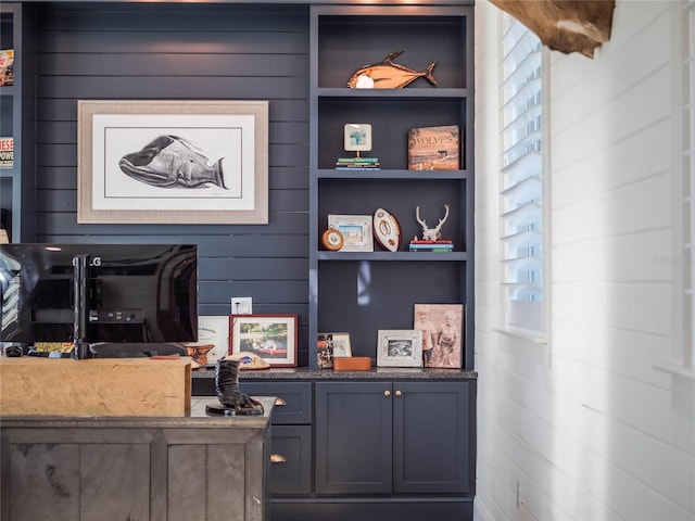 interior space featuring built in shelves and wood walls