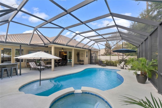 view of pool with an in ground hot tub, glass enclosure, an outdoor bar, and a patio area