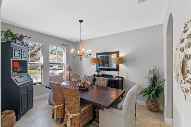 dining area featuring light tile patterned floors and an inviting chandelier