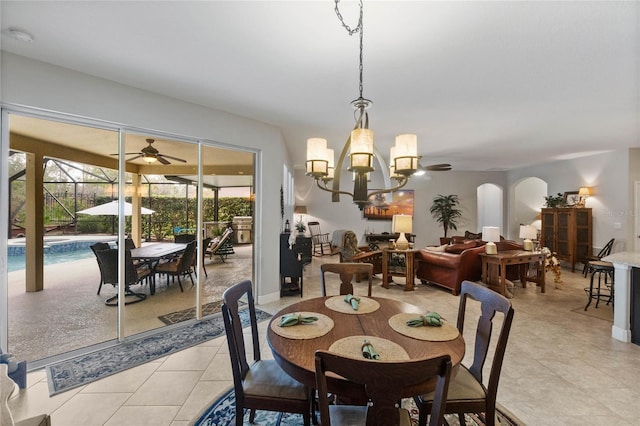 dining area with light tile patterned floors and ceiling fan with notable chandelier