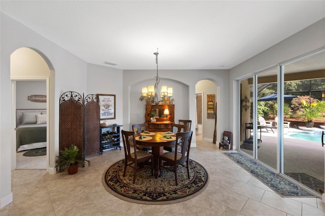 tiled dining room with a chandelier