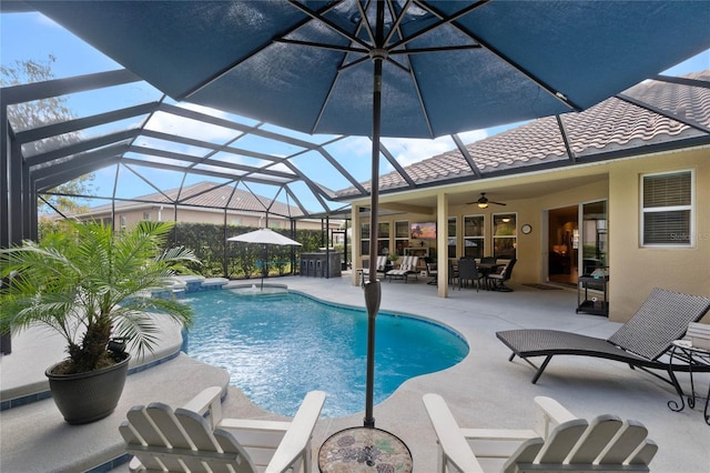 view of pool with glass enclosure, ceiling fan, and a patio