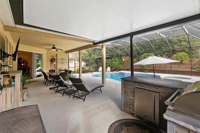 view of patio / terrace featuring glass enclosure, a grill, exterior kitchen, and ceiling fan