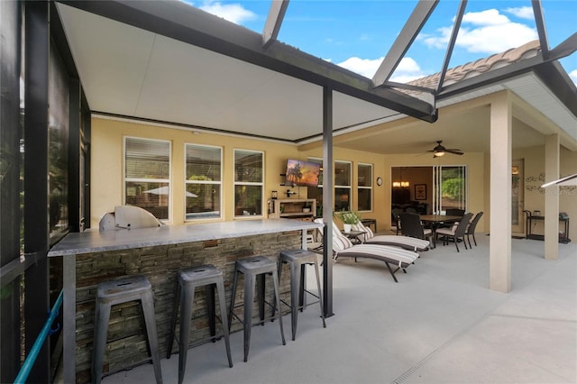 view of patio with ceiling fan, exterior bar, and grilling area