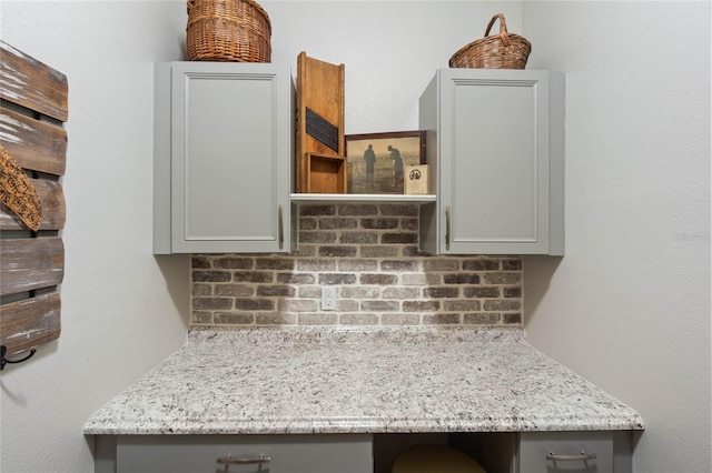 interior details featuring built in desk and tasteful backsplash