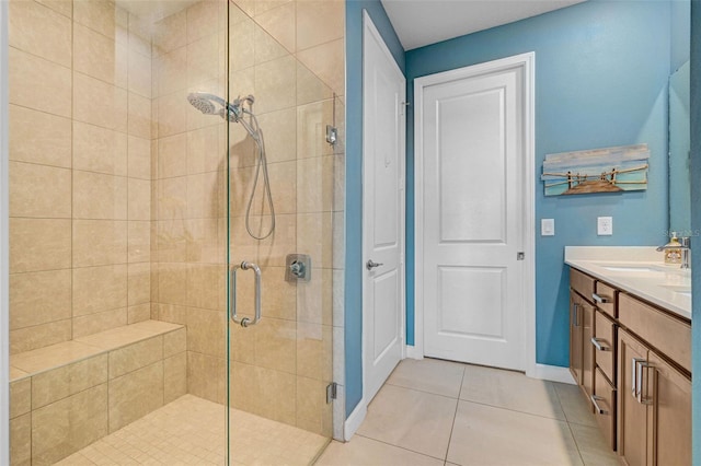 bathroom featuring baseboards, a stall shower, vanity, and tile patterned floors