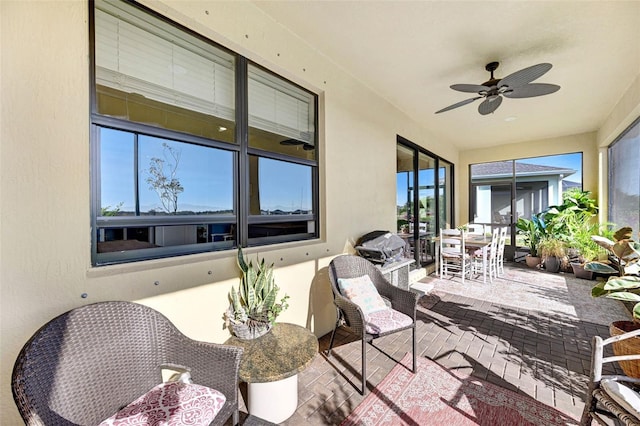 sunroom / solarium featuring a ceiling fan