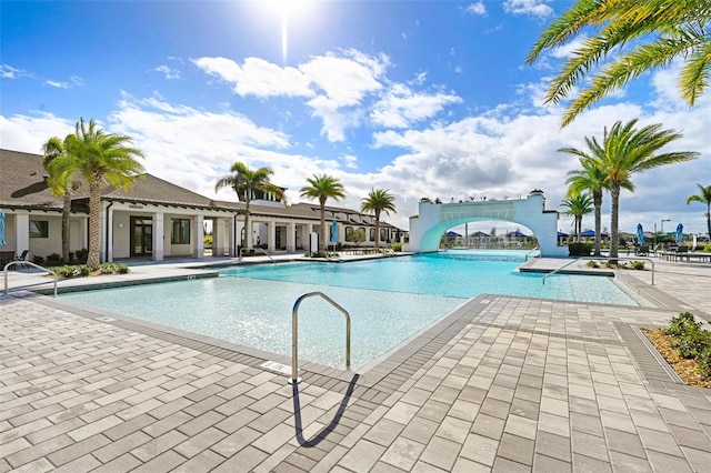 community pool with a patio and a water slide