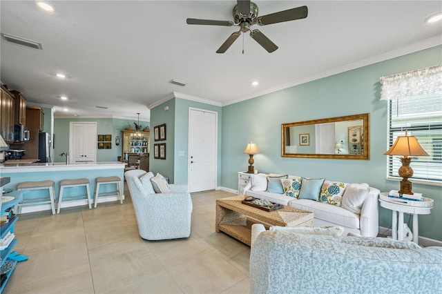 living area with baseboards, visible vents, crown molding, and light tile patterned flooring