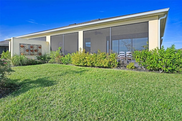 exterior space with a sunroom and a lawn