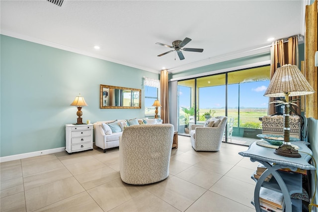 living area featuring light tile patterned floors, baseboards, ornamental molding, and a ceiling fan