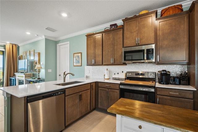 kitchen with light tile patterned floors, stainless steel appliances, a sink, visible vents, and backsplash