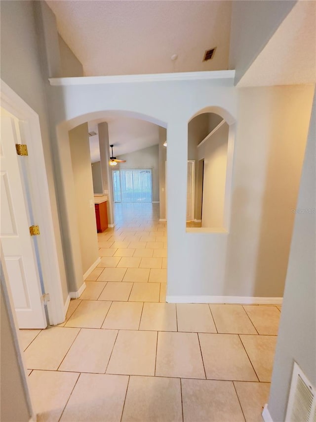 corridor with lofted ceiling and light tile patterned floors