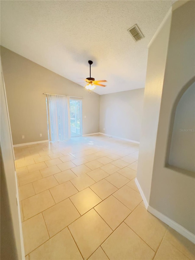 unfurnished room featuring light tile patterned floors, a textured ceiling, ceiling fan, and lofted ceiling