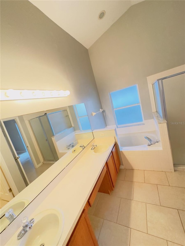 bathroom with vanity, tile patterned flooring, a relaxing tiled tub, and high vaulted ceiling