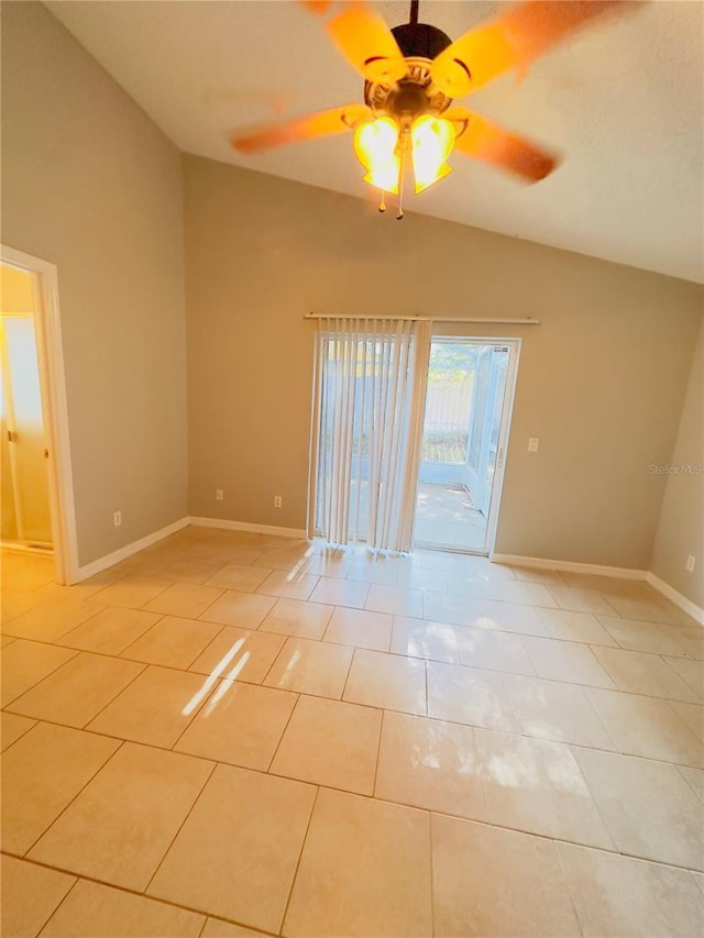 empty room featuring ceiling fan, light tile patterned flooring, and vaulted ceiling