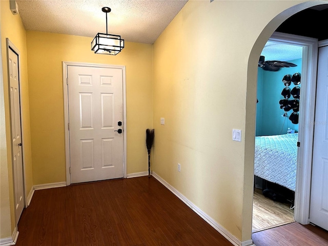 entryway featuring dark wood-type flooring and a textured ceiling