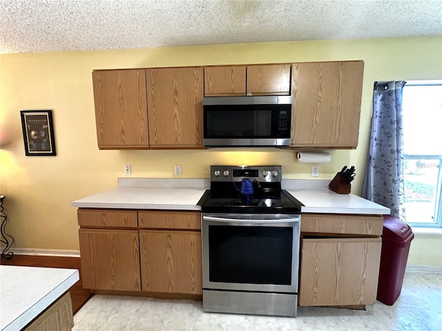 kitchen with a textured ceiling and stainless steel appliances