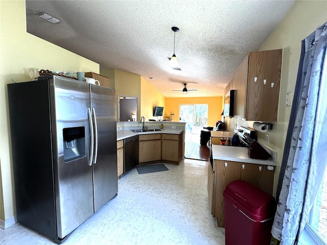 kitchen with ceiling fan, stainless steel appliances, kitchen peninsula, a textured ceiling, and decorative light fixtures