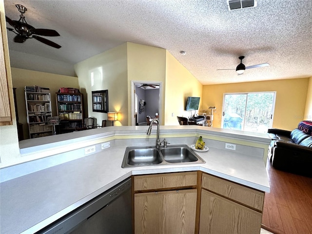 kitchen featuring sink, stainless steel dishwasher, a textured ceiling, light brown cabinetry, and hardwood / wood-style flooring