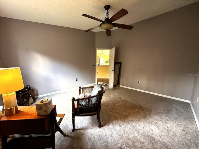 sitting room with ceiling fan, a textured ceiling, and dark colored carpet