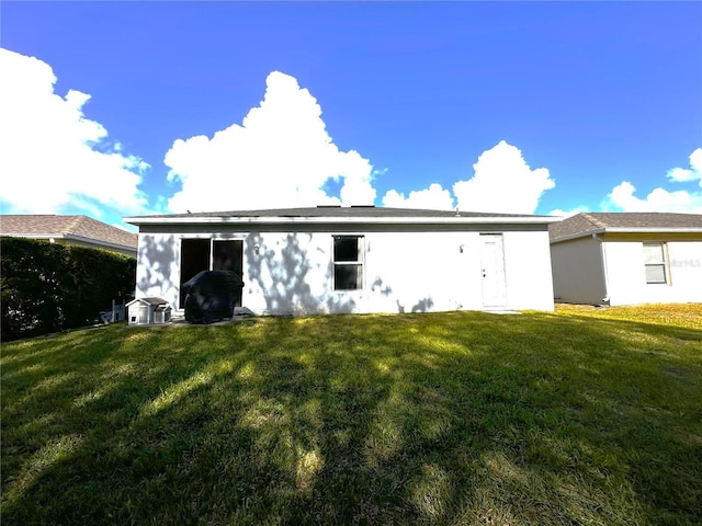 rear view of house featuring a yard