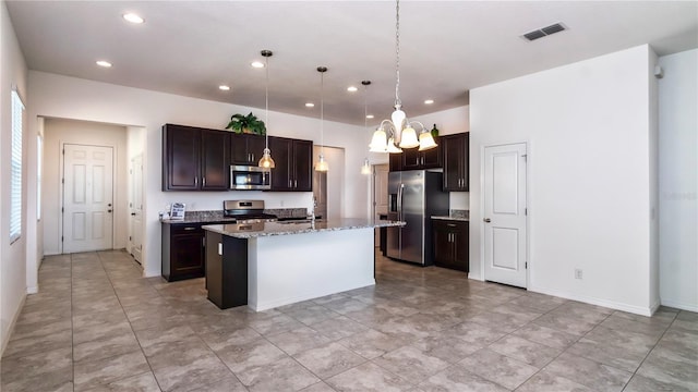 kitchen featuring dark brown cabinetry, a kitchen island with sink, pendant lighting, and stainless steel appliances