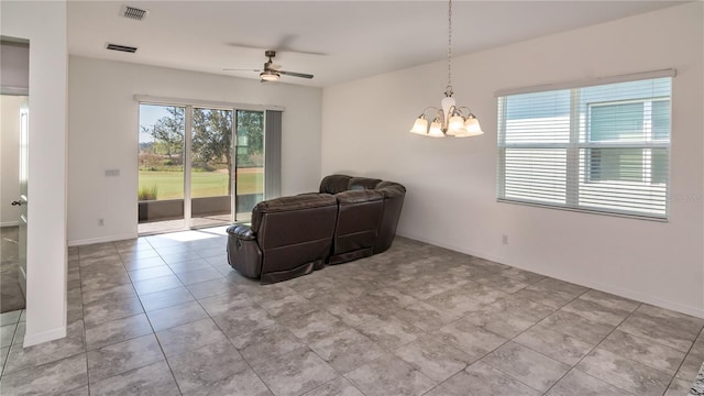 tiled living room with ceiling fan with notable chandelier