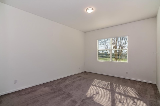 unfurnished room featuring dark colored carpet