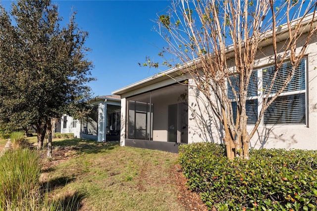 exterior space featuring a sunroom and a lawn