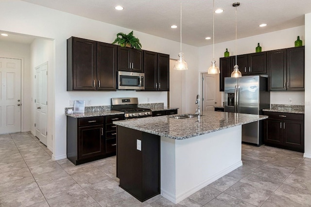 kitchen with appliances with stainless steel finishes, a center island with sink, pendant lighting, and sink