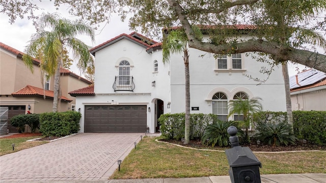 mediterranean / spanish-style home featuring a front lawn and a garage