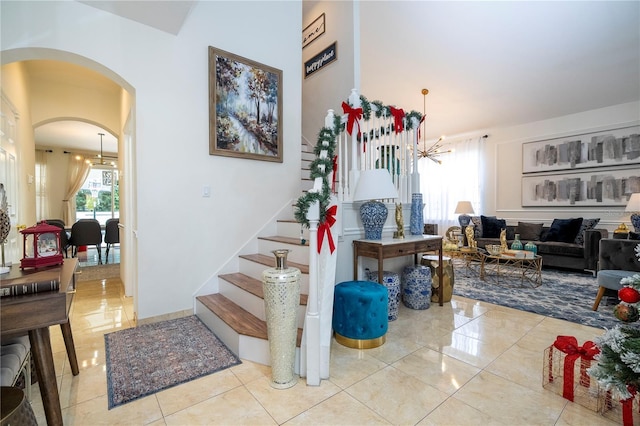 11410 Rapallo Ln, Windermere, FL 34786 - stairs with a chandelier, arched walkways, and tile patterned flooring