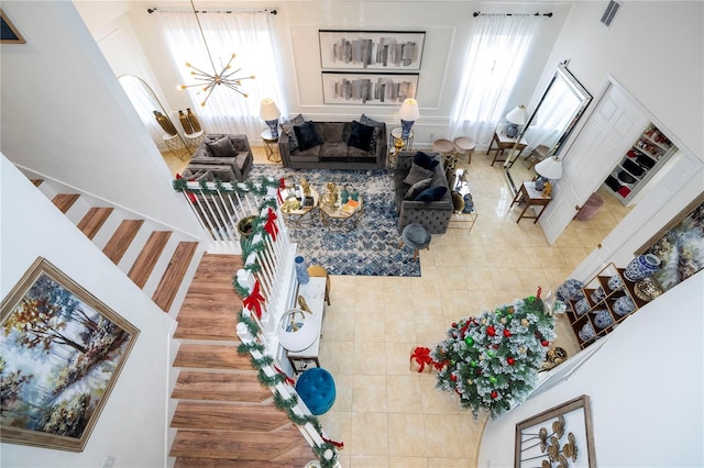 living room featuring tile patterned flooring, a high ceiling, and an inviting chandelier