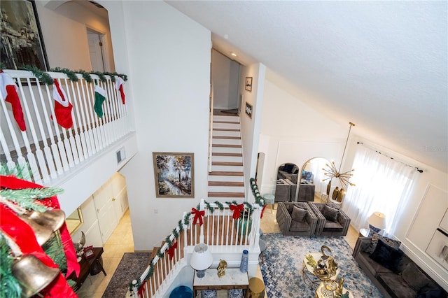 interior space with tile patterned flooring, high vaulted ceiling, and a notable chandelier