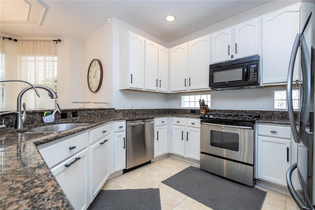 11410 Rapallo Ln, Windermere, FL 34786 - kitchen with stainless steel appliances, white cabinets, dark stone countertops, plenty of natural light, and recessed lighting