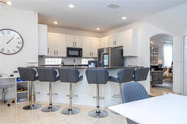 11410 Rapallo Ln, Windermere, FL 34786 - kitchen featuring stainless steel fridge with ice dispenser, black microwave, arched walkways, a peninsula, and a breakfast bar