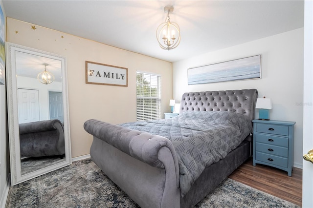 bedroom with dark wood-type flooring and a notable chandelier