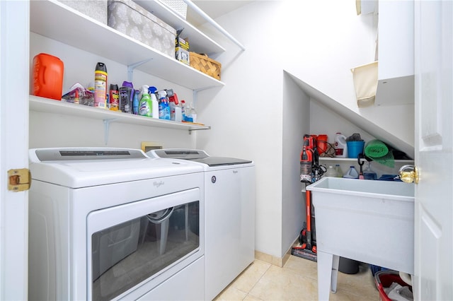 laundry area with independent washer and dryer and light tile patterned floors