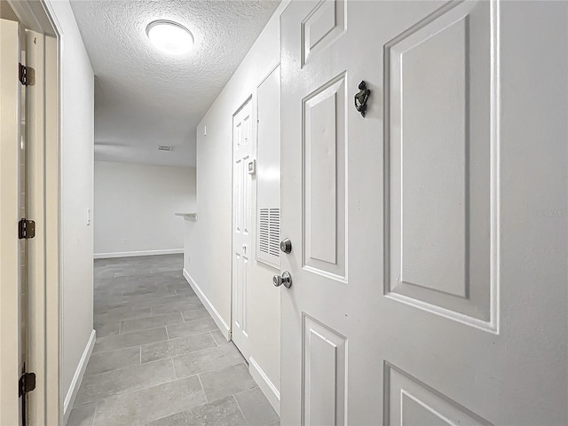 hall with a textured ceiling